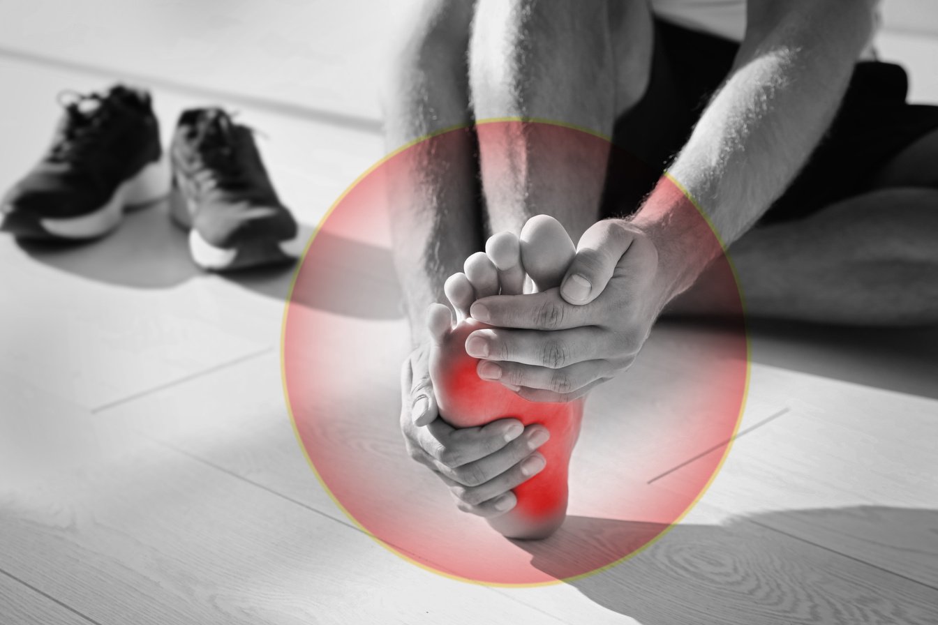 Man Suffering from Foot Pain on Floor Indoors, Closeup