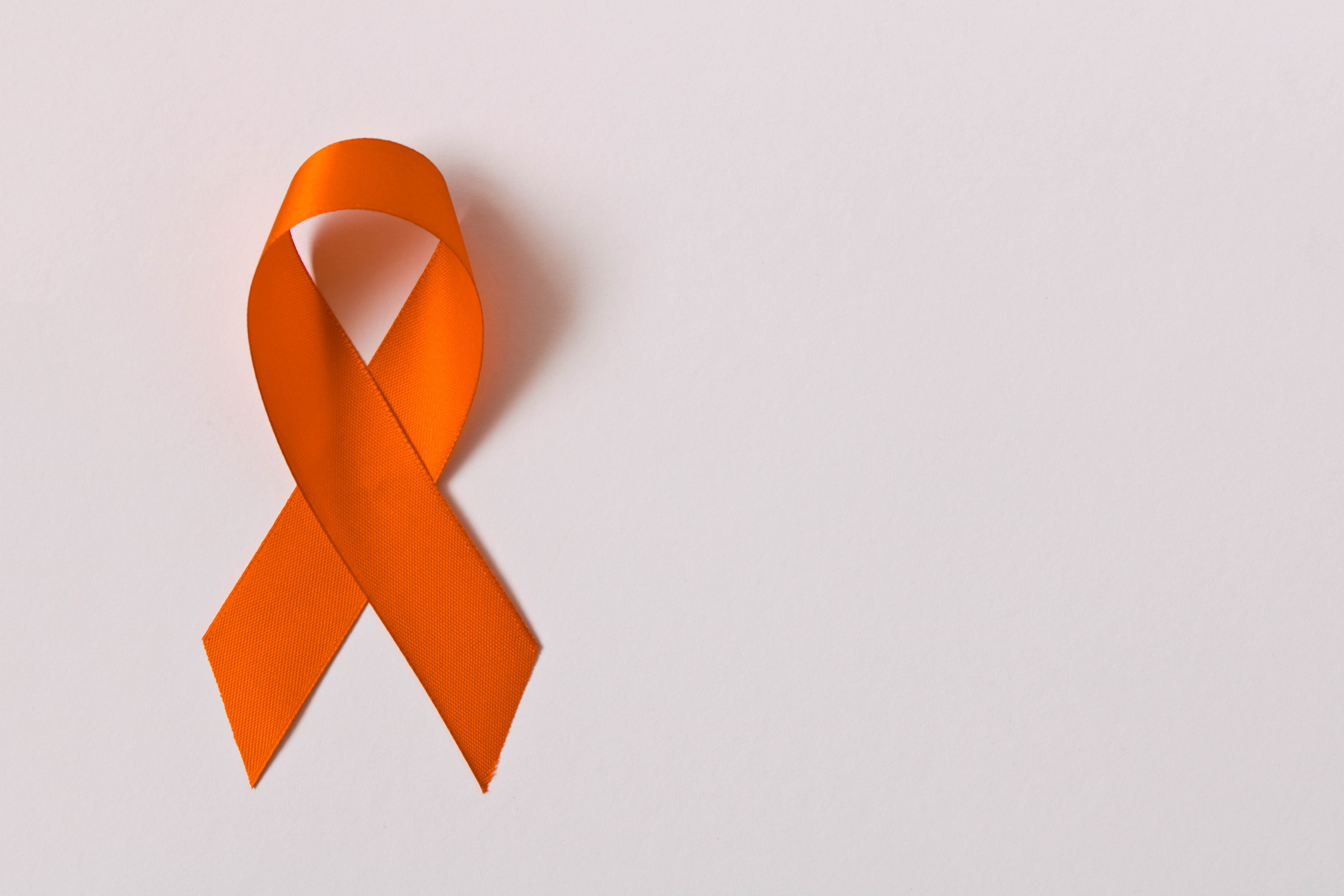 Orange ribbon on white background . Healthcare and medicine concept. Multiple Sclerosis awareness. Leukemia awareness. Empty text space.